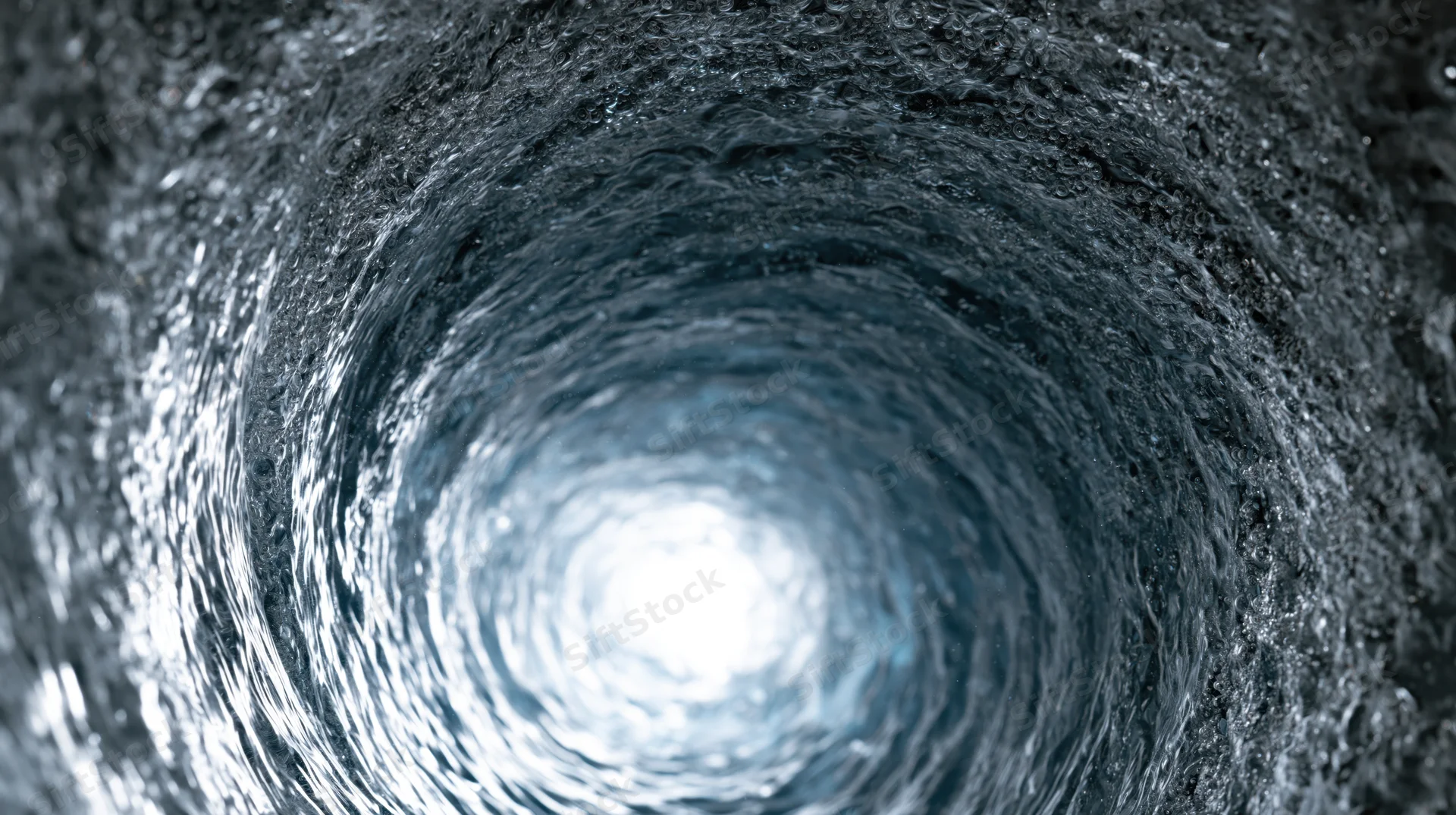 Swirling water forming a vortex tunnel with light at the center