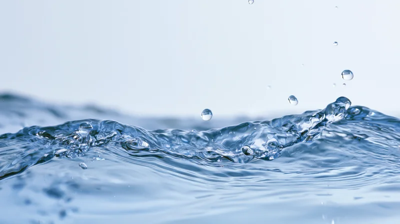 Close-up of water surface with splashing droplets and ripples