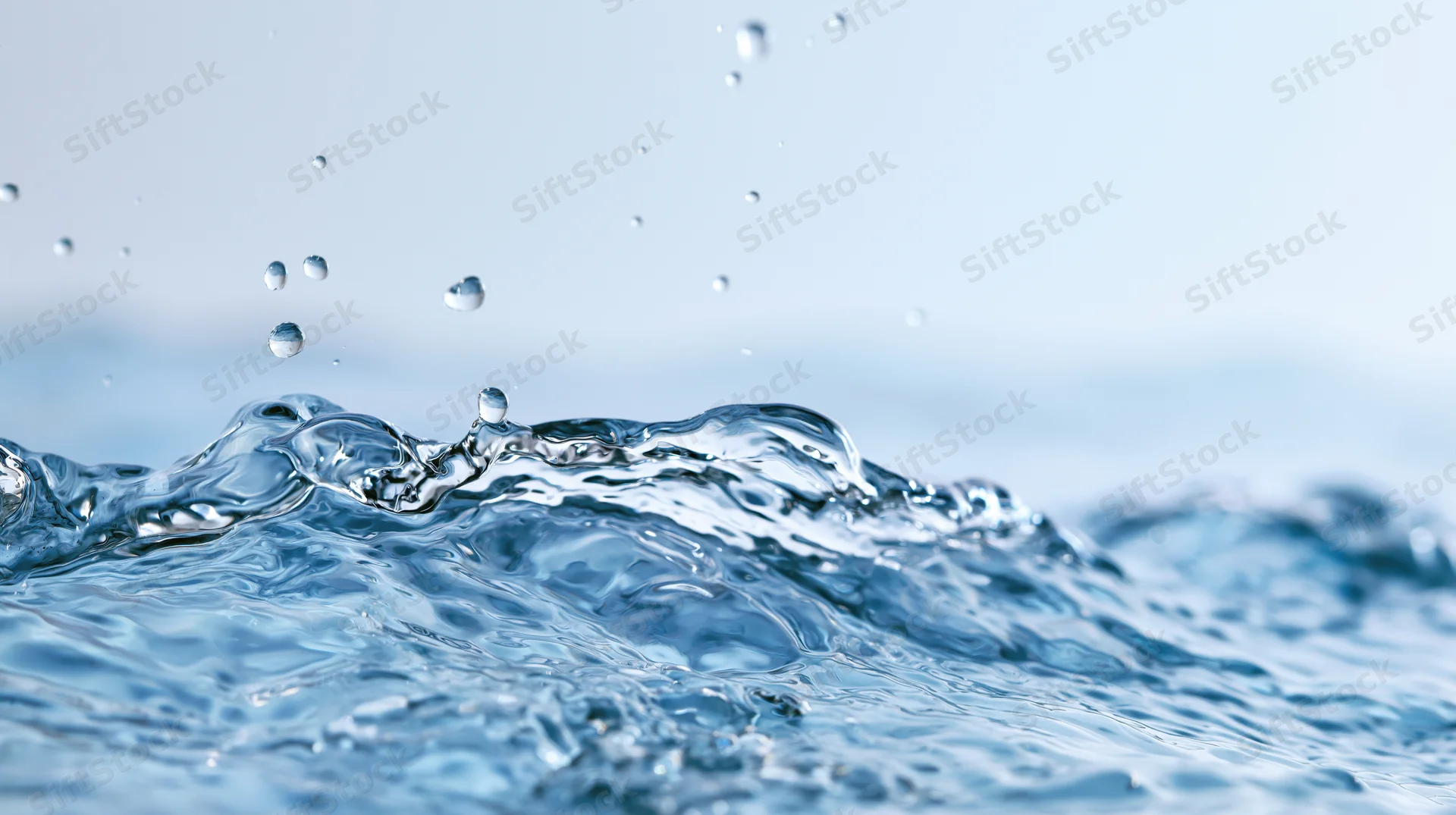 Close-up of water surface mid-splash with droplets and ripples