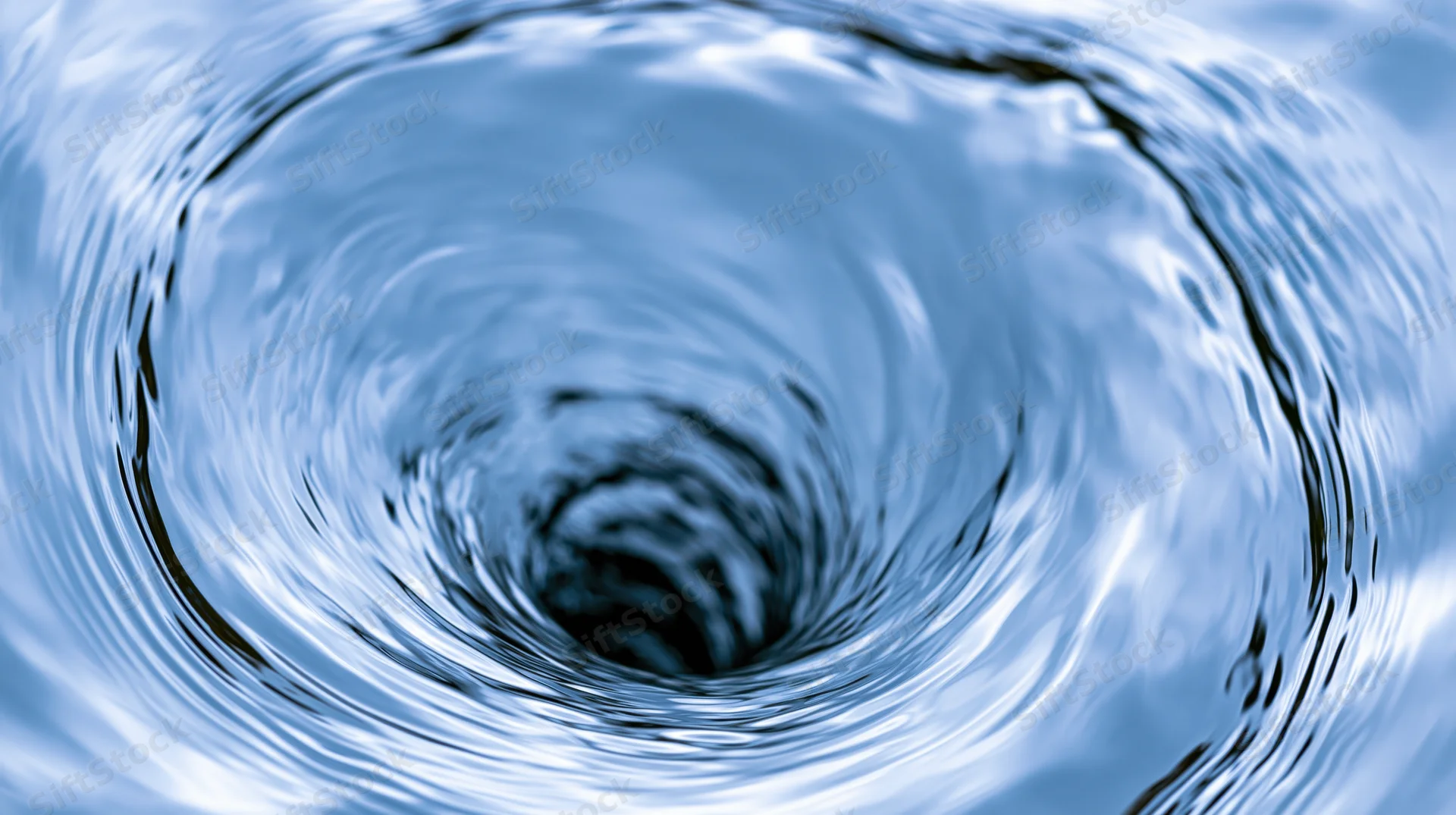 Close-up of a spinning water vortex forming a tight spiral with ripples and light reflections on the surface