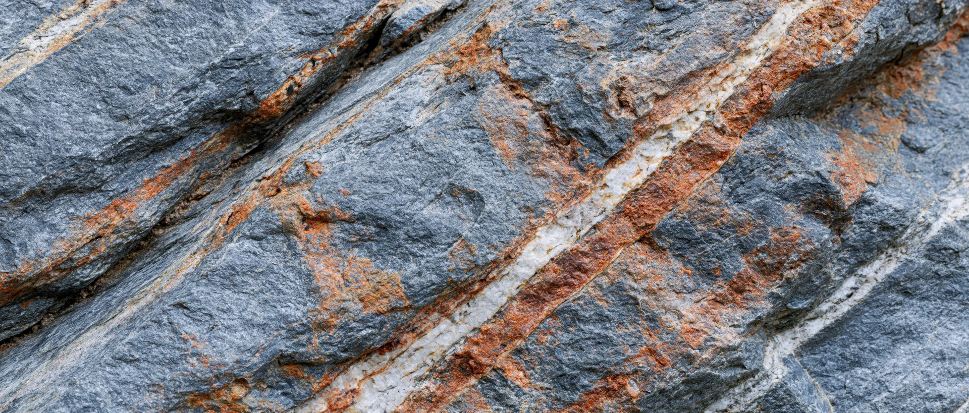 Close-up of rough granite rock surface with visible mineral veins and fractures