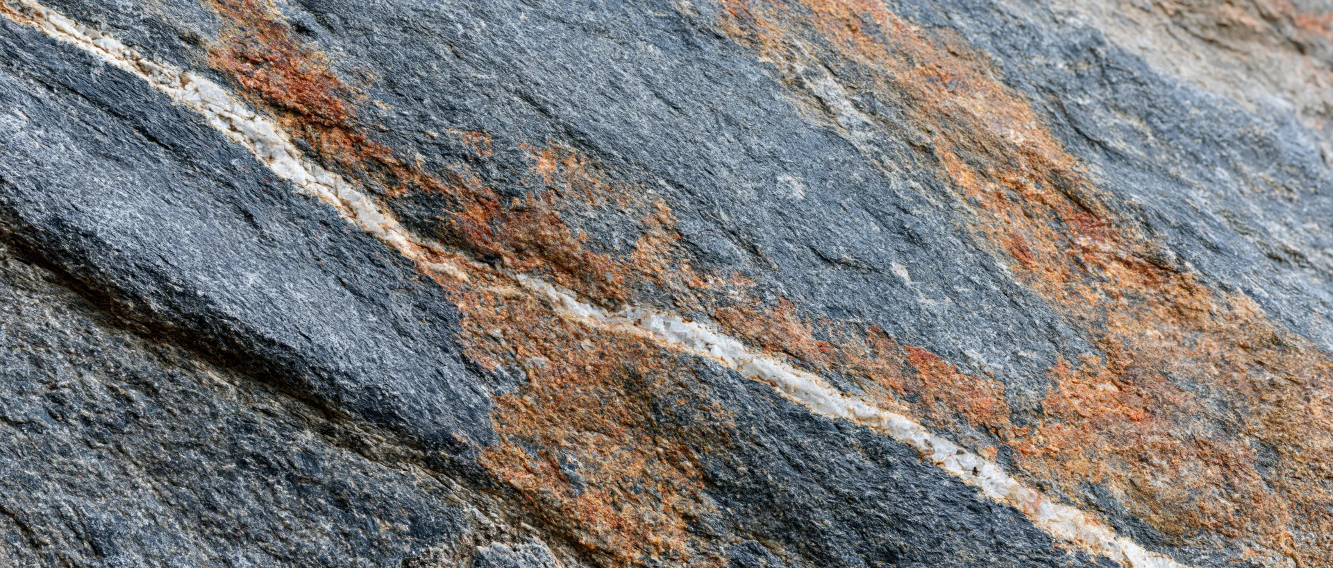 Close-up of rough granite rock surface with visible mineral veins and weathered texture