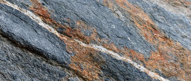 Close-up of rough granite rock surface with visible mineral veins and weathered texture