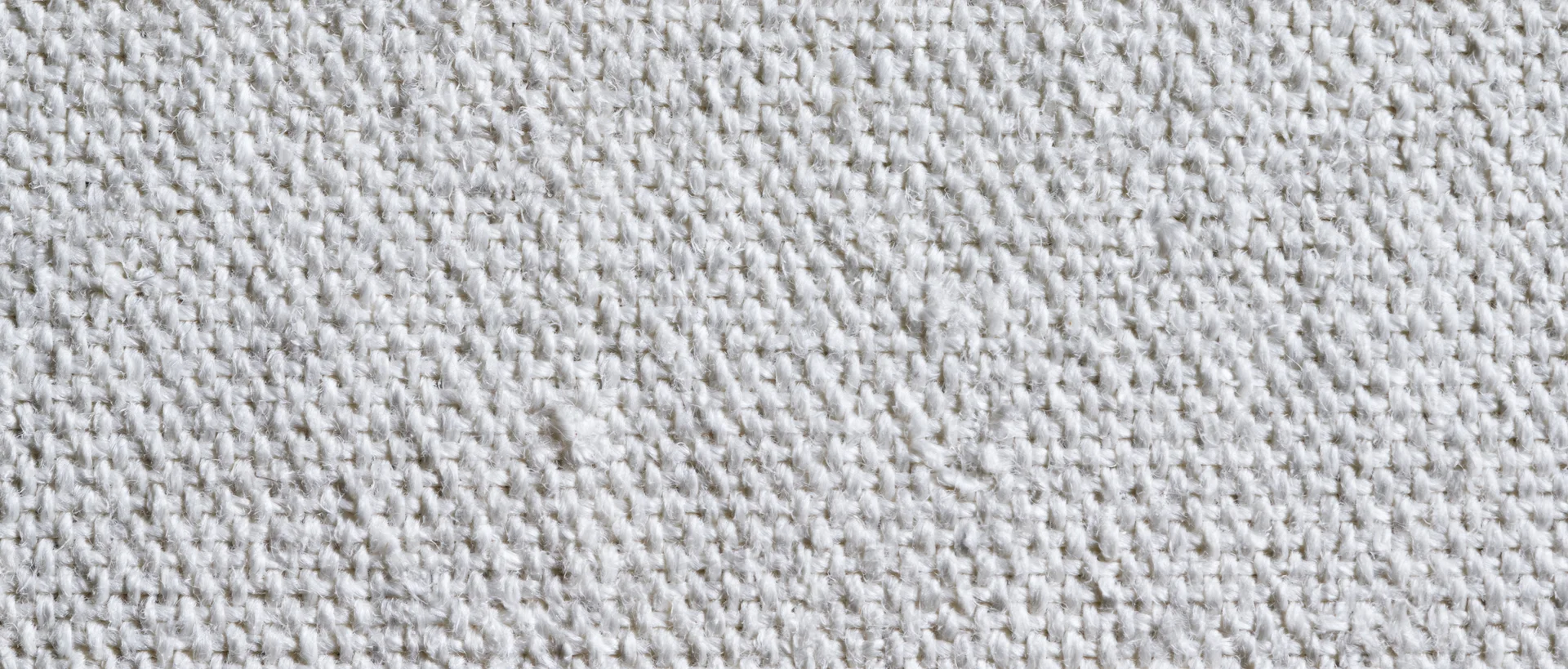 Close-up of white canvas textile surface showing woven texture and thread pattern