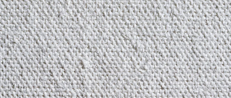 Close-up of white canvas textile surface showing woven texture and thread pattern