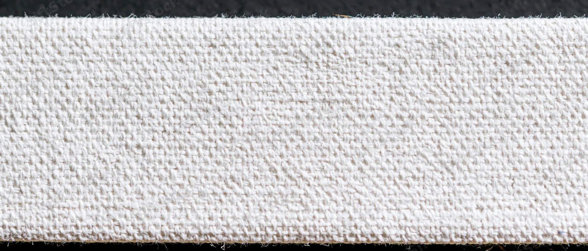 Close-up of white canvas textile surface showing woven texture and natural fiber weave