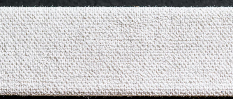Close-up of white canvas textile surface showing woven texture and natural fiber weave