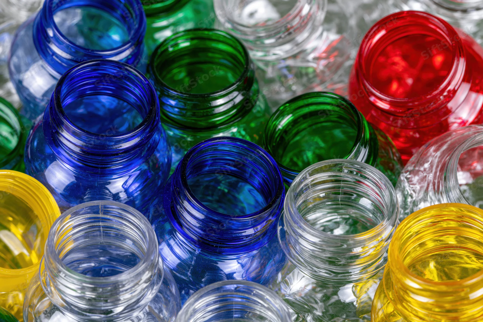 Scattered empty plastic bottles in various colors viewed from above