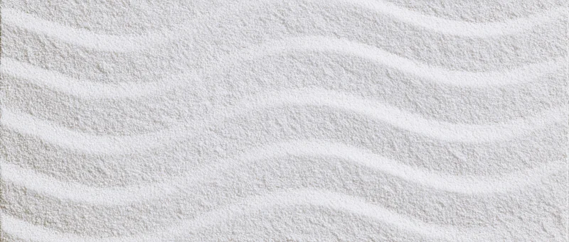 Raked white sand forming wavy patterns in a Japanese garden