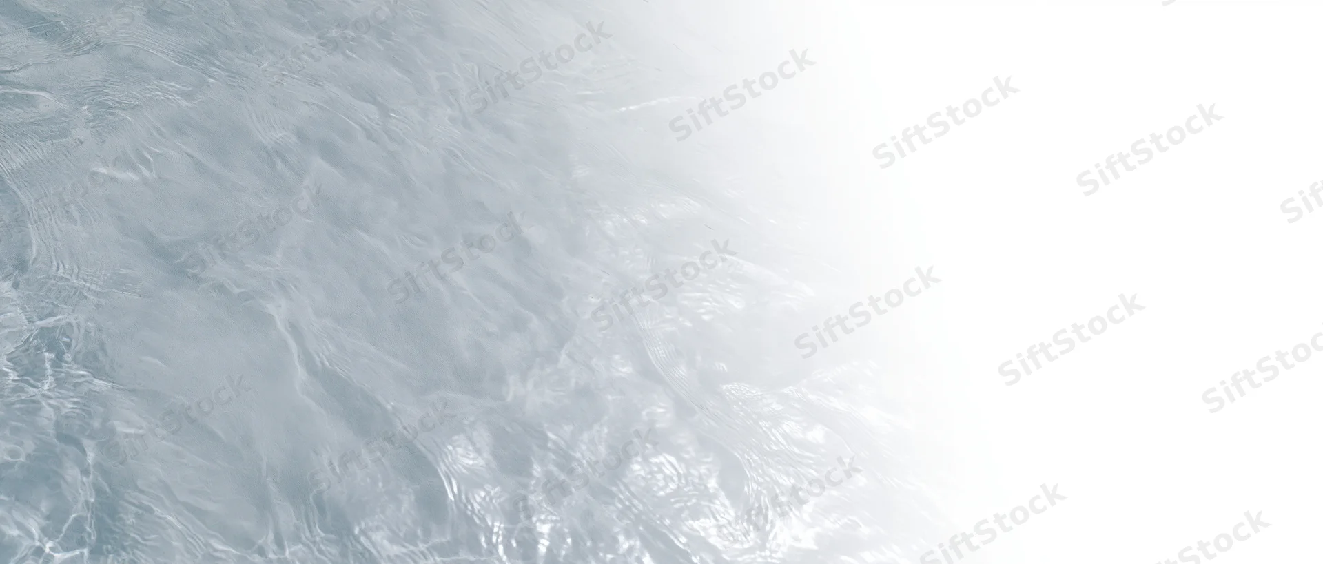 Close-up overhead view of clear shallow water surface with gentle ripples and light reflections