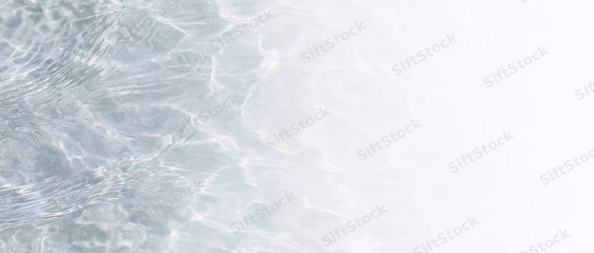 Clear shallow water surface with ripples and light reflections, overhead view