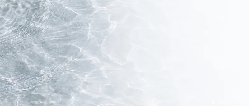 Clear shallow water surface with ripples and light reflections, overhead view