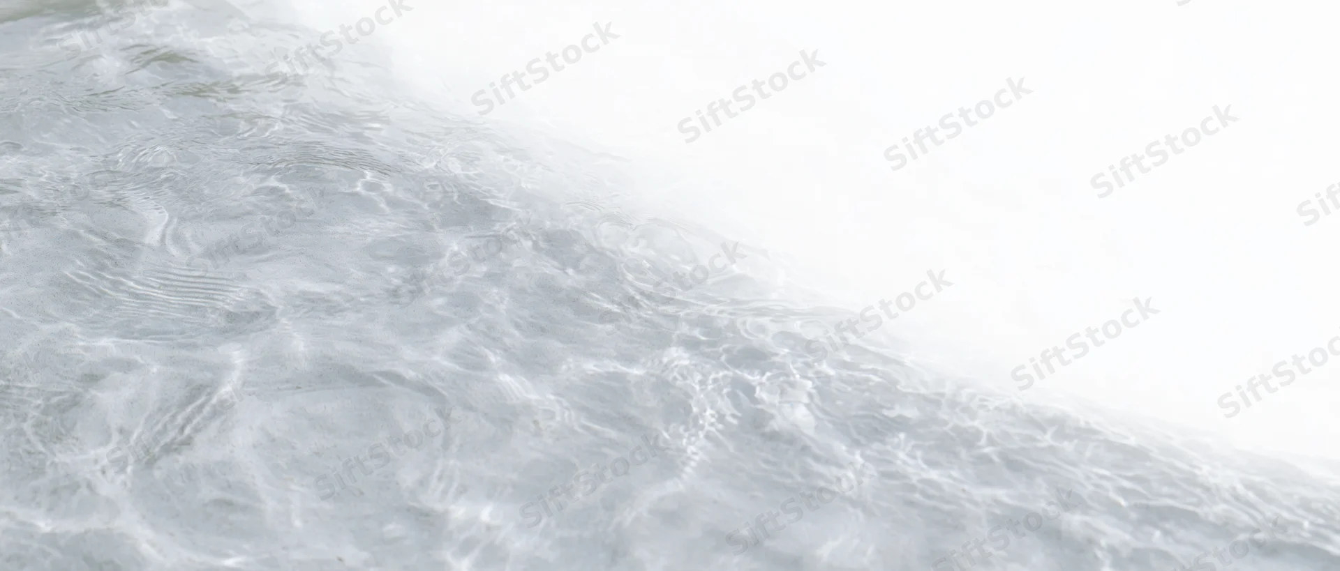 Close-up of clear shallow water surface with ripples and light reflections