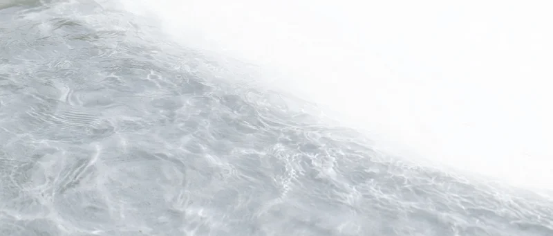 Close-up of clear shallow water surface with ripples and light reflections
