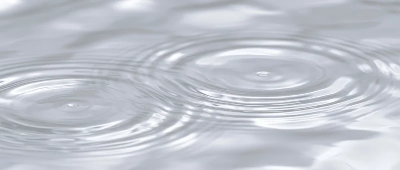 Close-up of concentric ripples spreading across a calm water surface