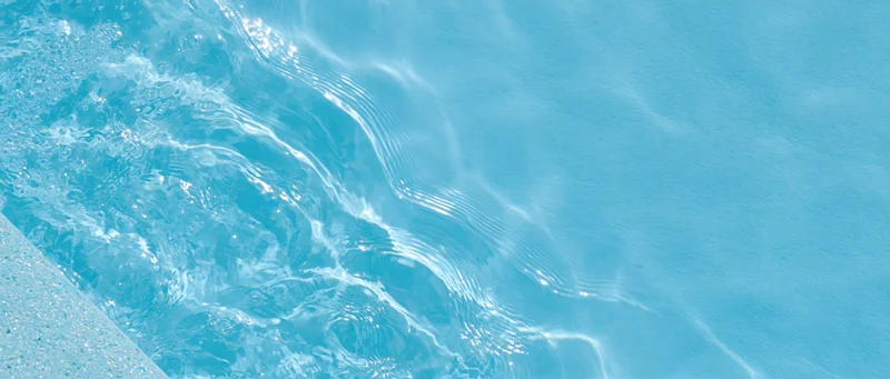Overhead closeup of clear blue water with ripples and light reflections in a swimming pool