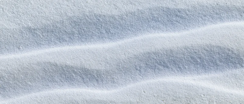 Smooth white beach sand with rippled texture in overhead closeup view