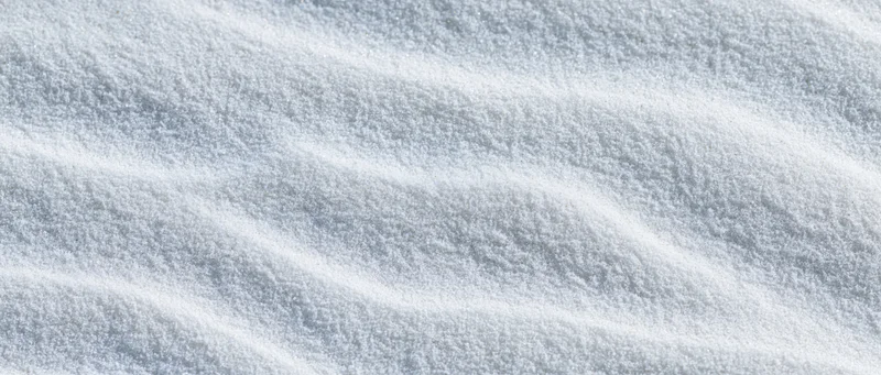 Close-up overhead view of smooth white beach sand with shallow ripples and natural texture