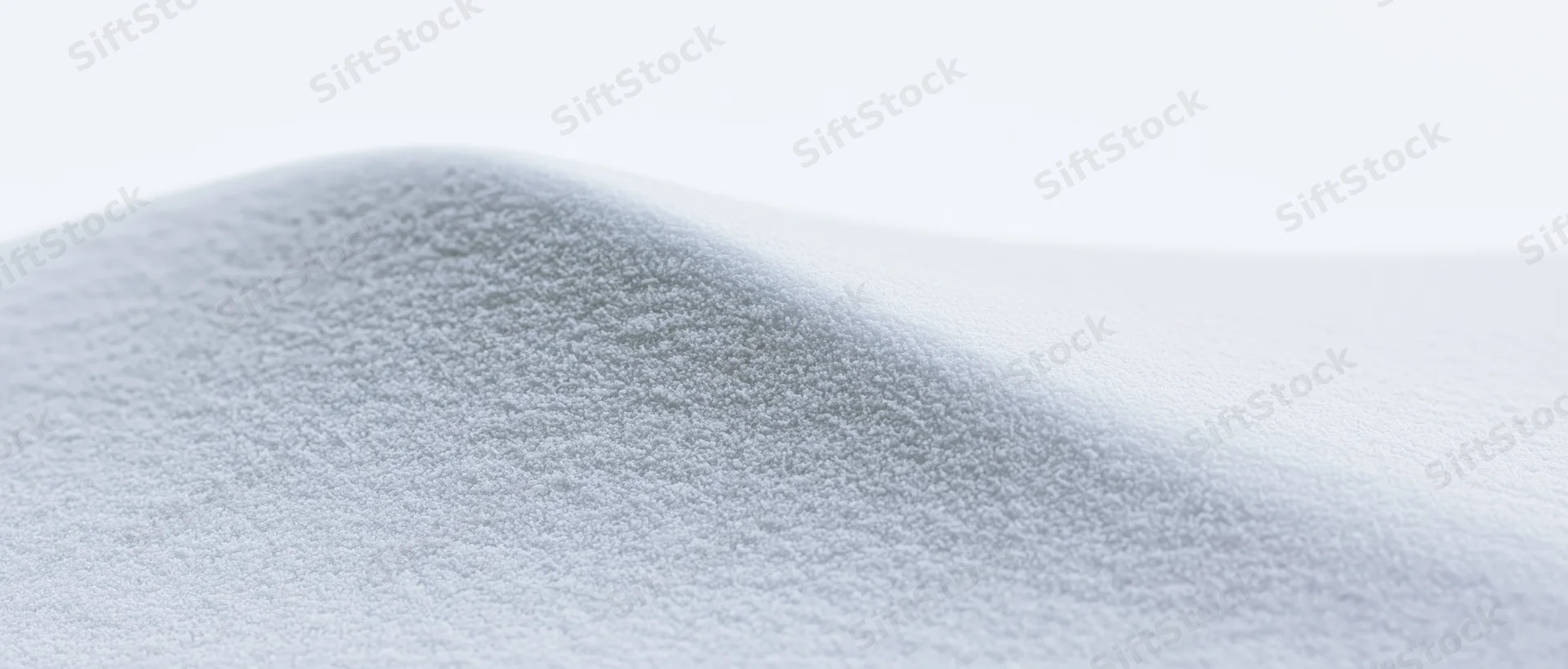 Close-up of smooth snow surface forming a gentle curve under soft light