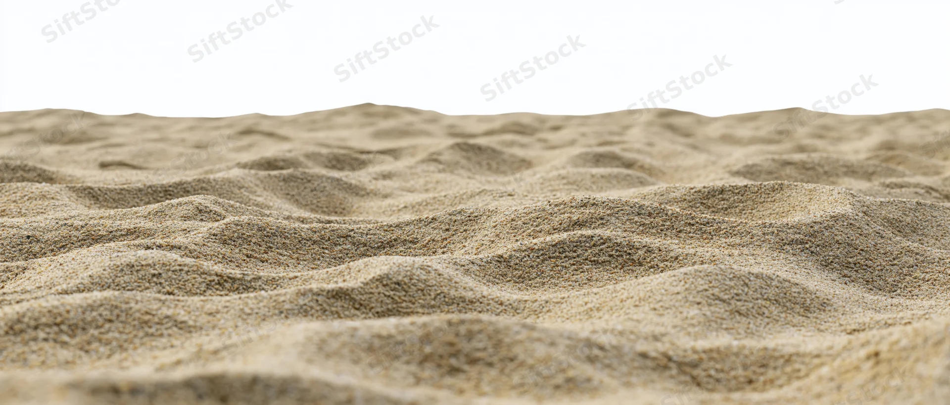 Close-up of rippled dry beach sand surface with white background