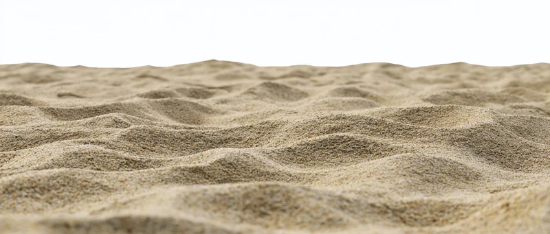 Close-up of rippled dry beach sand surface with white background
