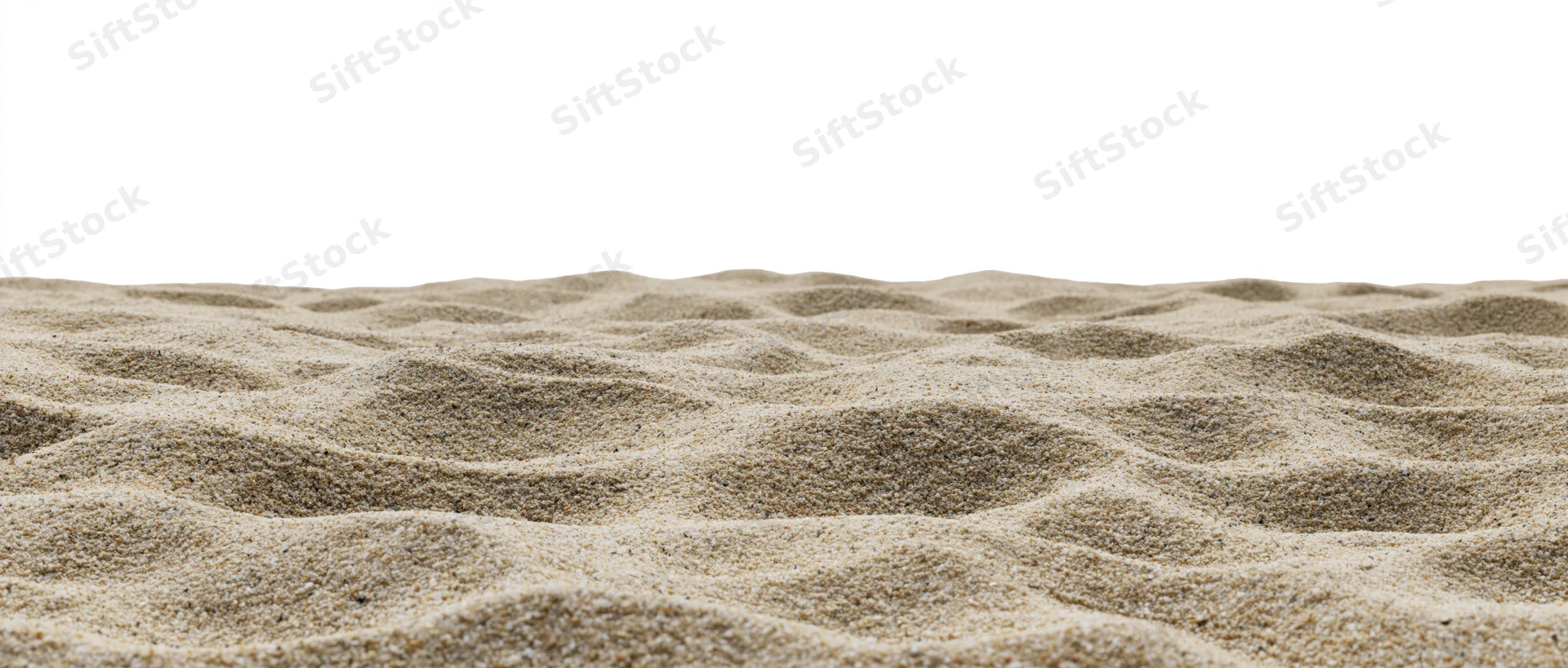Close-up of rippled dry beach sand surface against white background