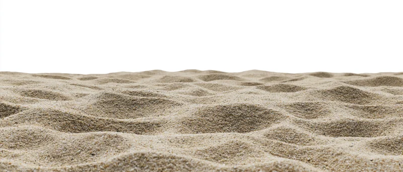 Close-up of rippled dry beach sand surface against white background