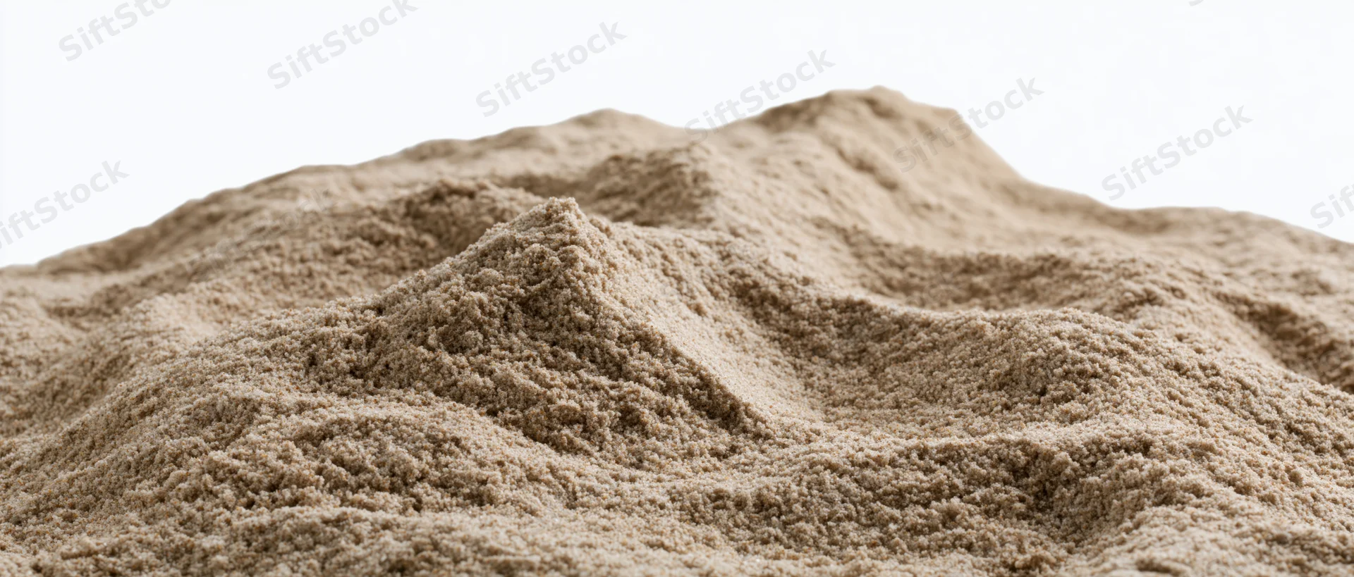 Close-up of a dry sand mound with uneven ridges and textured surface against white background