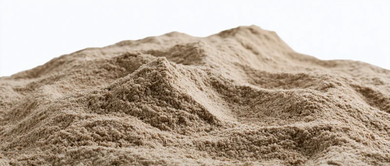 Close-up of a dry sand mound with uneven ridges and textured surface against white background