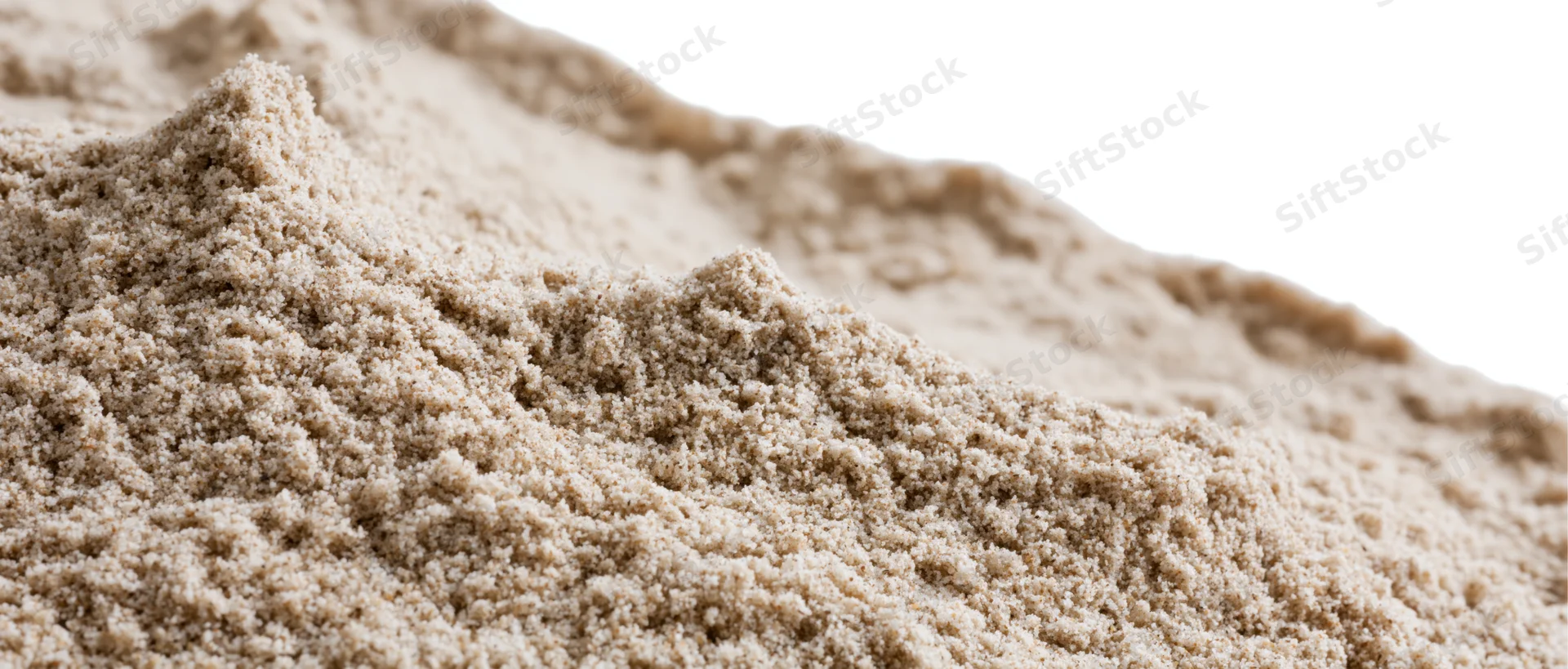 Close-up of a dry sand mound with uneven ridges and granular texture against a white background