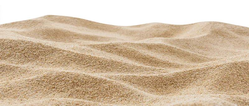 Close-up of rippled dry beach sand with small dunes on white background