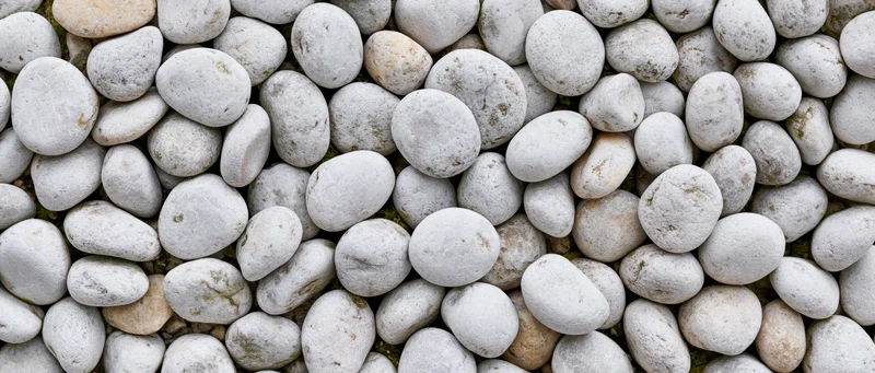 Smooth rounded river pebbles arranged in a dense overhead flat-lay pattern