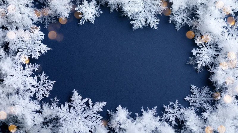 Frosty snowflake frame border on blue background with golden bokeh lights and copyspace