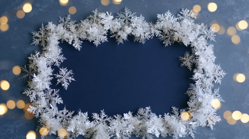 White frost snowflake frame border on blue background with golden bokeh lights