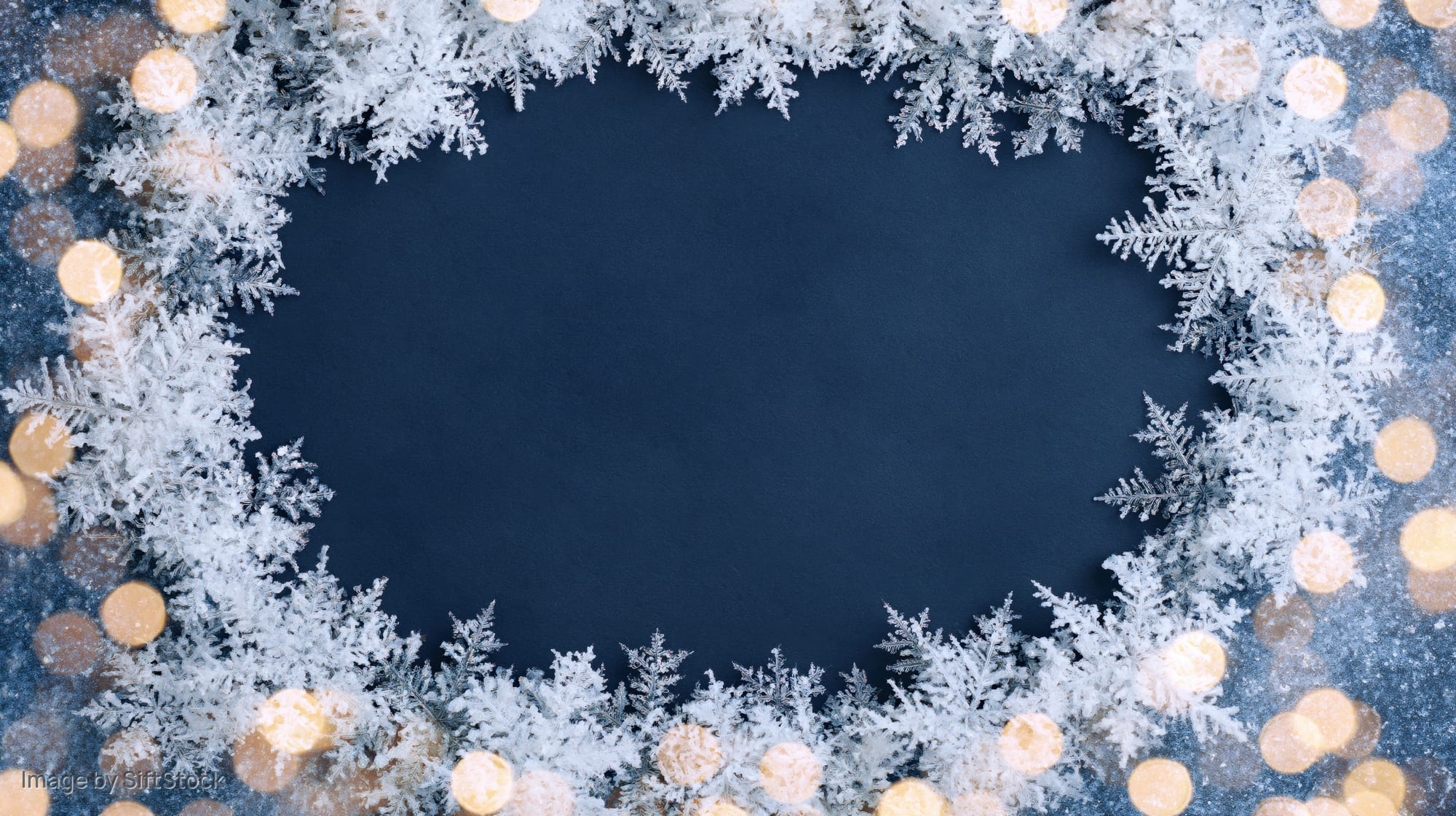 Circular frosty snowflake frame border with bokeh lights on dark blue background