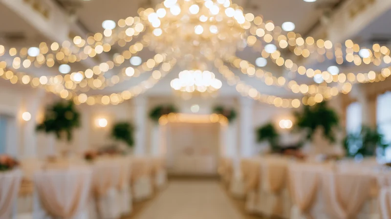 Defocused view of an elegant wedding reception interior with string lights and tables arranged for guests