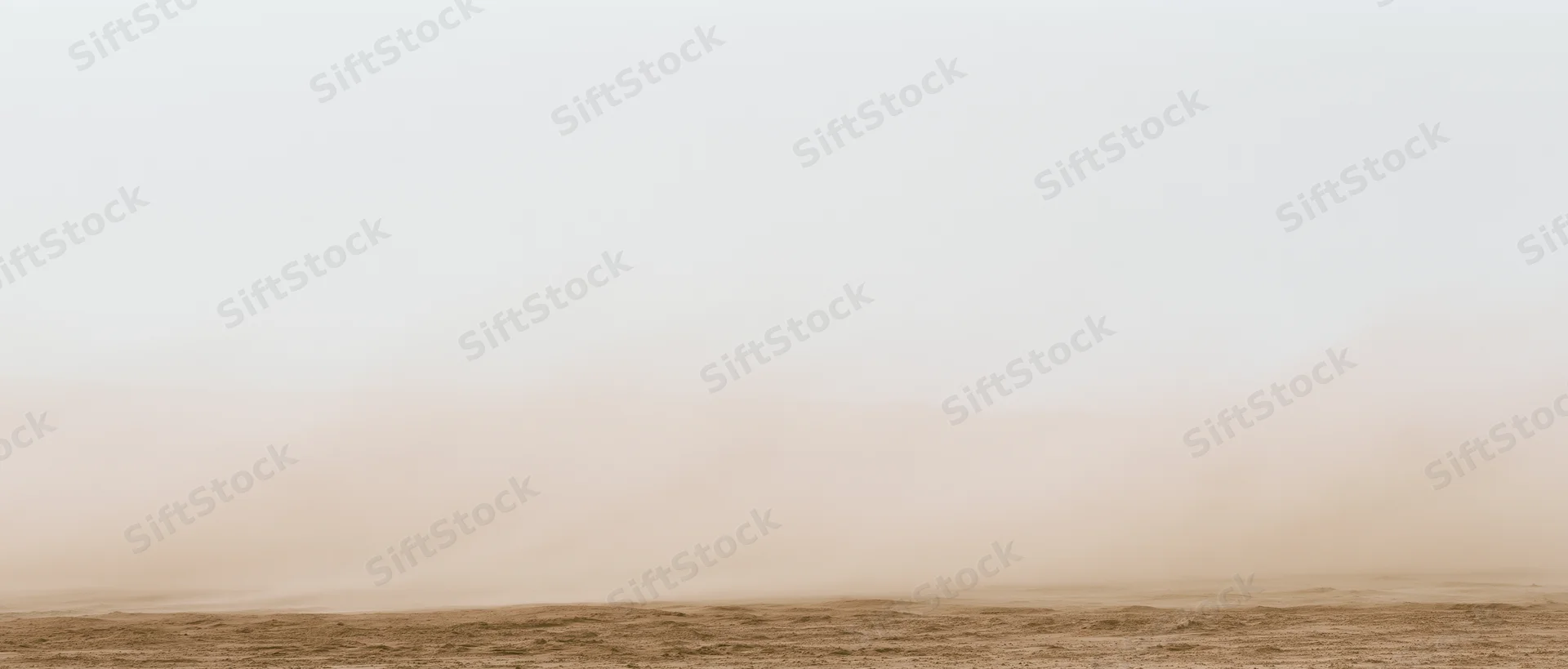 Dense dust cloud billowing low across dry desert floor under overcast sky