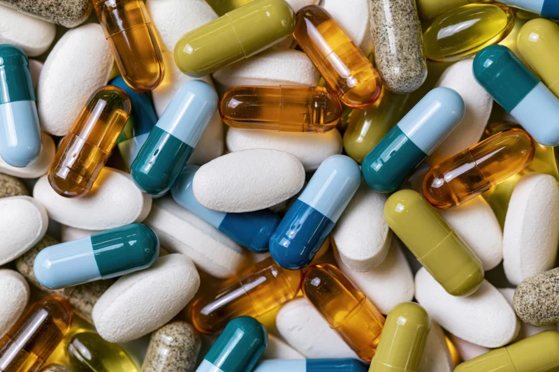 Assorted medication capsules and tablets scattered in close-up view