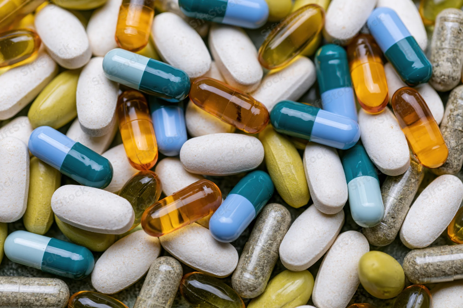 Assorted medication capsules and tablets scattered in close-up view
