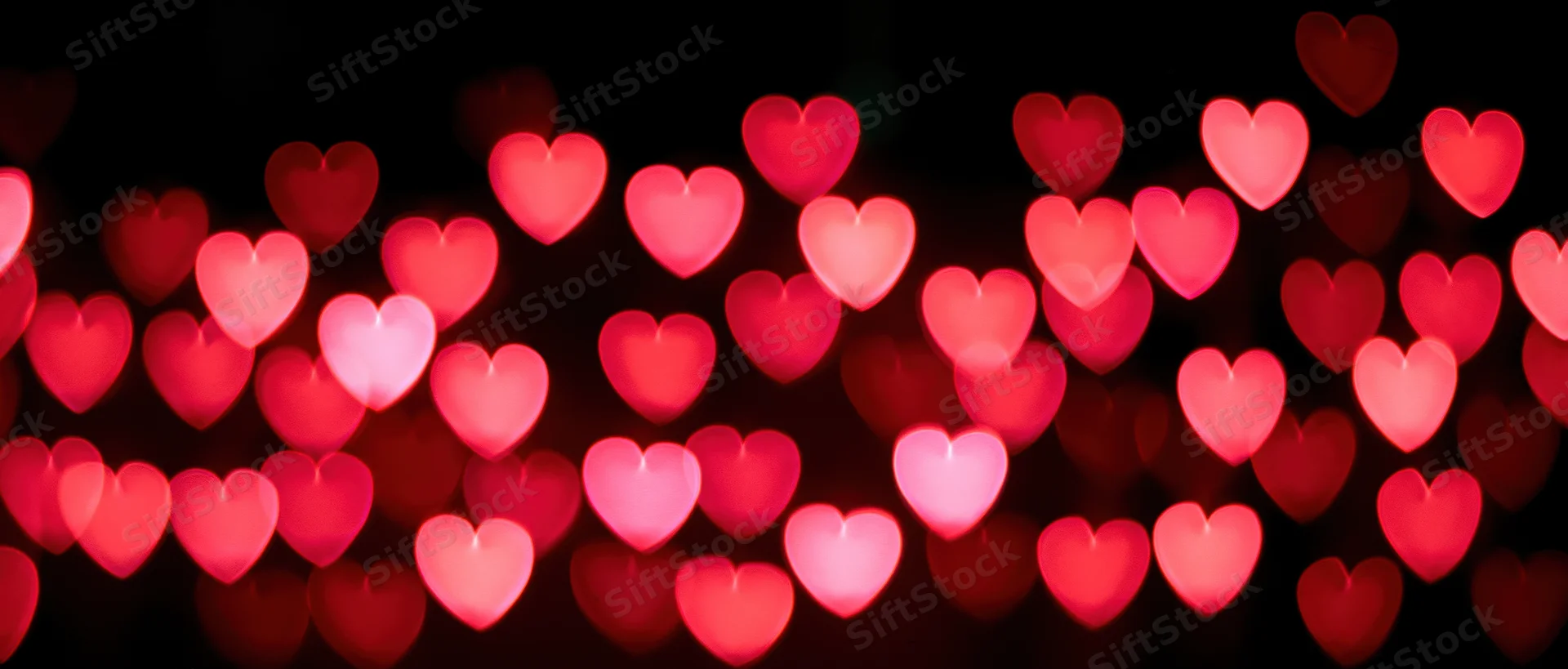 Soft out-of-focus heart-shaped bokeh lights filling the frame against a dark background