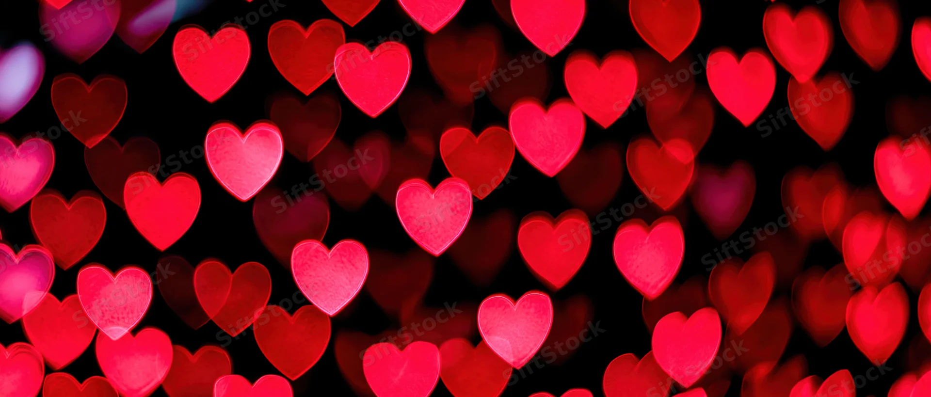 Soft out-of-focus heart-shaped bokeh lights filling the frame against a dark background