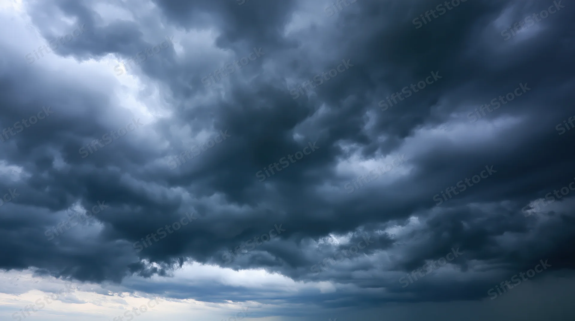 Dark cumulonimbus clouds filling the sky with dramatic stormy atmosphere