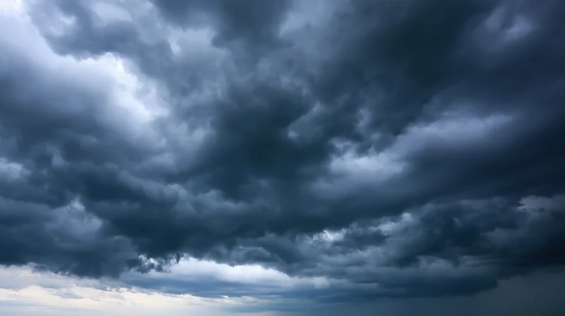 Dark cumulonimbus clouds filling the sky with dramatic stormy atmosphere