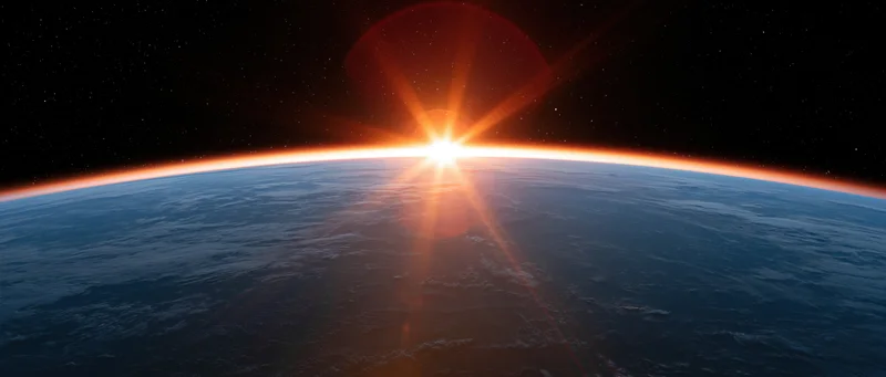 Earth's curved horizon from low orbit with sunrise glowing along the edge