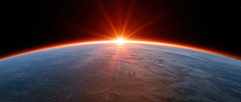 Earths curved horizon from low orbit with sun rising directly over the planet