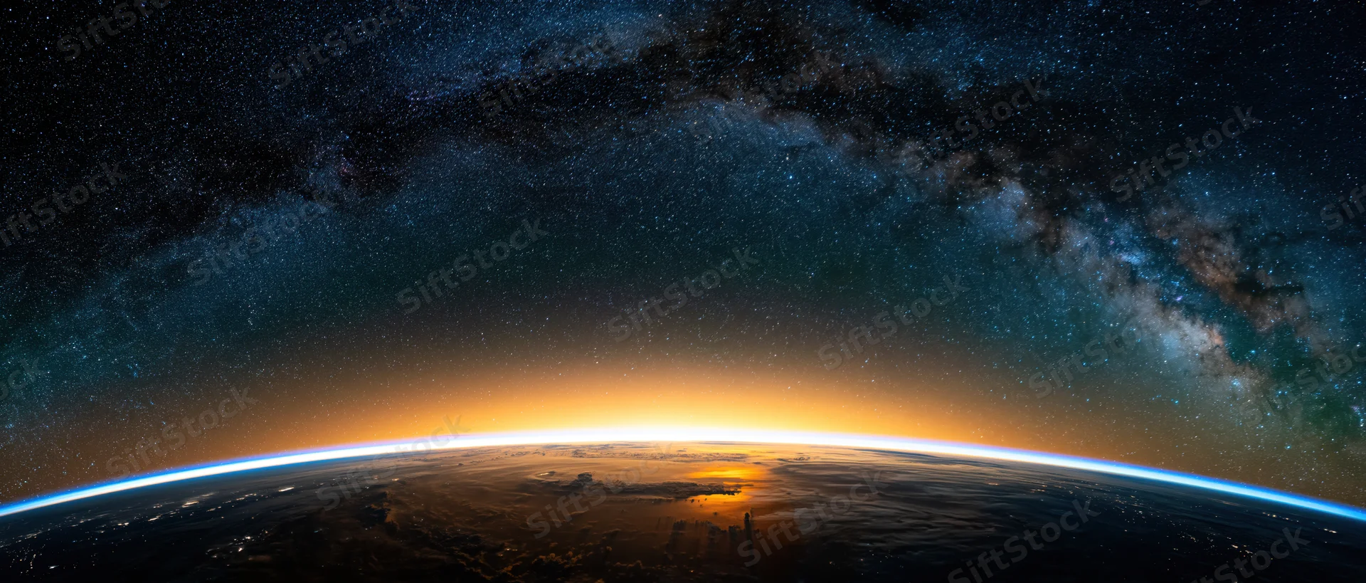 Earths curved horizon from low orbit during golden sunrise with milky way above