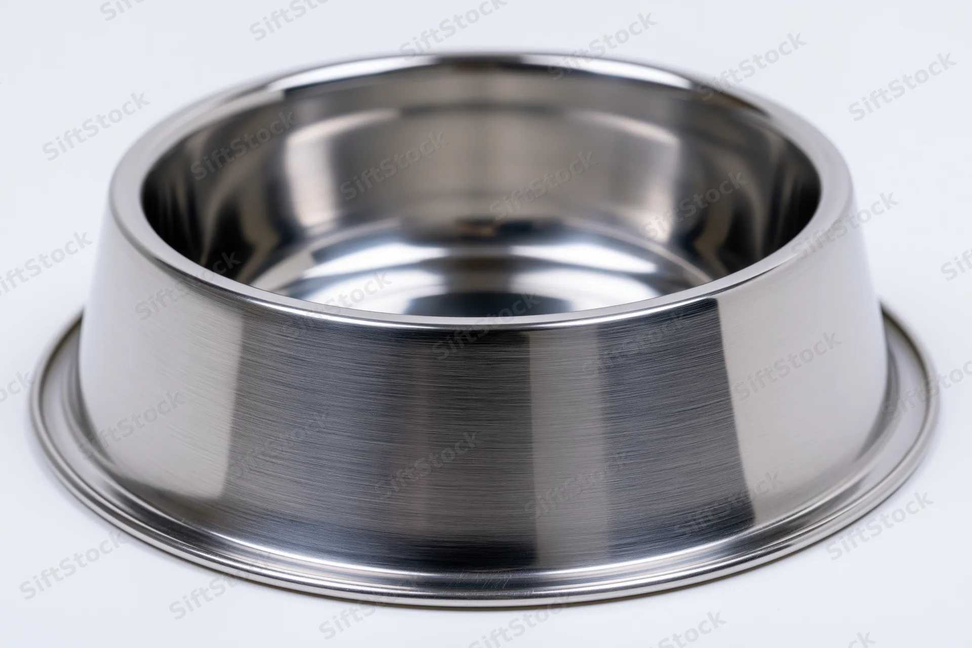 Empty stainless steel pet food bowl sitting upright isolated on white background
