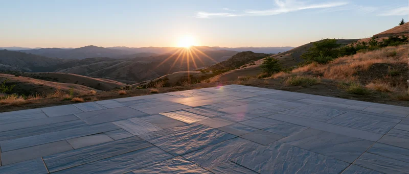 Stone tile plaza floor in a wide outdoor view at sunset with mountains in the background