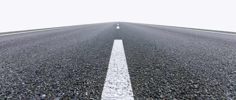 Straight asphalt road with white dashed center line receding into the distance
