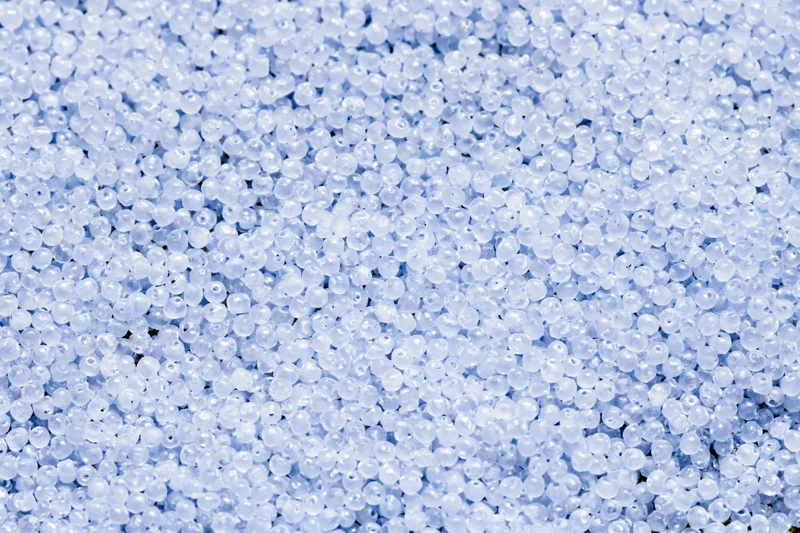 Close-up of translucent blue plastic beads covering a flat surface